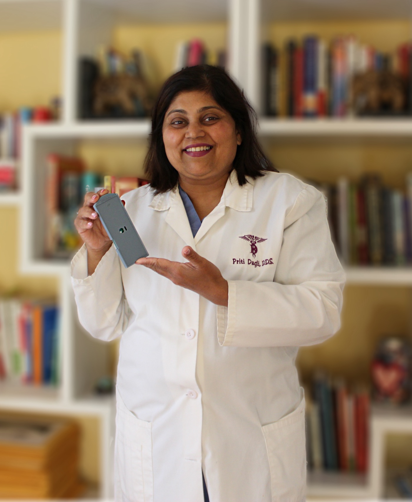 Dr. Priti Dagli, D.D.S., holding the Denticta operatory recorder